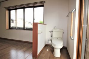 ご高齢の親御様の寝室にトイレスペースを設置。低い腰壁は目隠しだけではなく、手すり代わりにも。