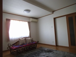 居間です。風通しがよく、非常に陽当たりの良い部屋になりました。梁の補強の為に天井が一部下がっていますが、そのため広がりのある空間になりました。