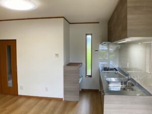 完成したキッチンと背面にカウンターキャビネットです。<br />
作業中はコンロ前に熱がこもり、暑くなってしまいます。風通しがよくなるようすべり出窓を設けました。